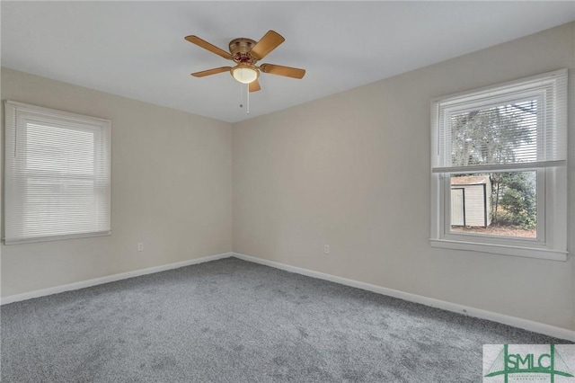 carpeted spare room featuring ceiling fan and baseboards