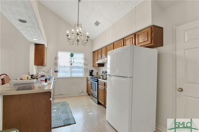 kitchen featuring visible vents, brown cabinetry, freestanding refrigerator, under cabinet range hood, and stainless steel electric range