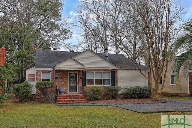 view of front of house with a front lawn and brick siding