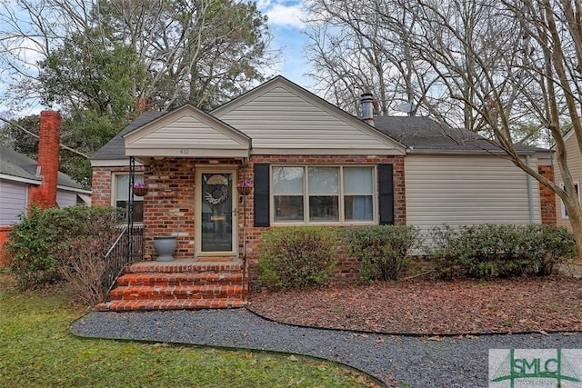 bungalow-style house featuring entry steps and brick siding