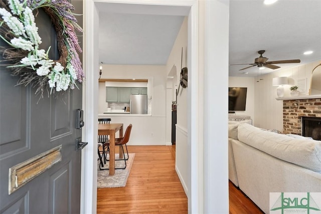 entrance foyer featuring a fireplace, wood finished floors, a ceiling fan, and recessed lighting