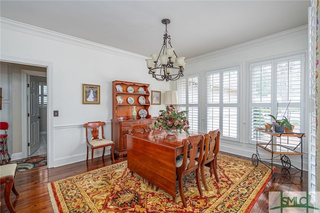 dining area with ornamental molding, a chandelier, dark wood-type flooring, and baseboards