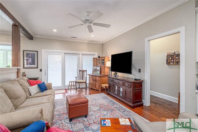 living area featuring crown molding, visible vents, ceiling fan, wood finished floors, and baseboards