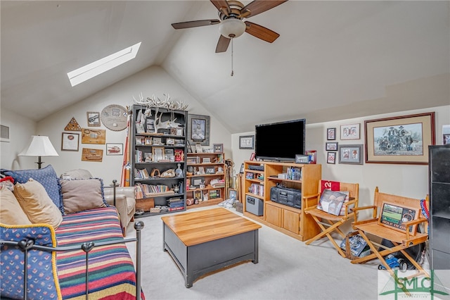 living room with lofted ceiling with skylight, carpet, and a ceiling fan