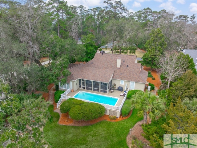 pool with a sunroom, a yard, and stairs