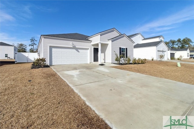 view of front of home featuring concrete driveway, a front lawn, an attached garage, and fence