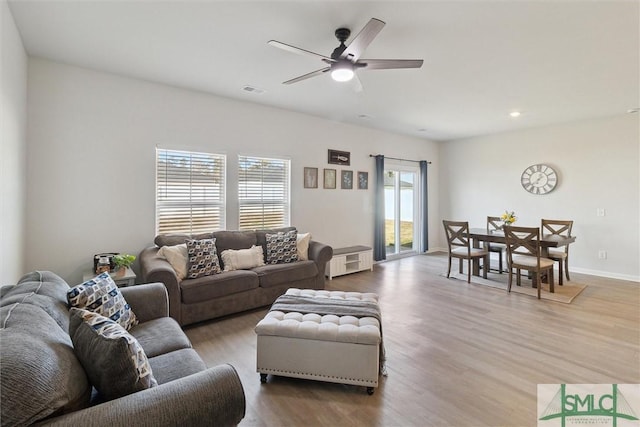 living room featuring ceiling fan, baseboards, wood finished floors, and recessed lighting
