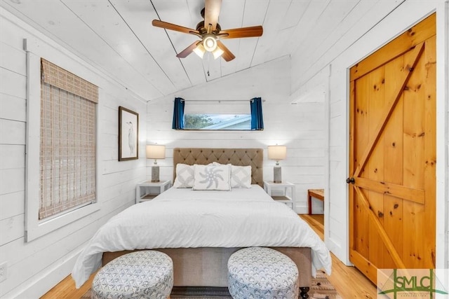 bedroom featuring lofted ceiling, wood ceiling, light wood-style flooring, and wooden walls