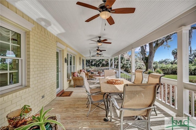 deck with outdoor dining area and a ceiling fan