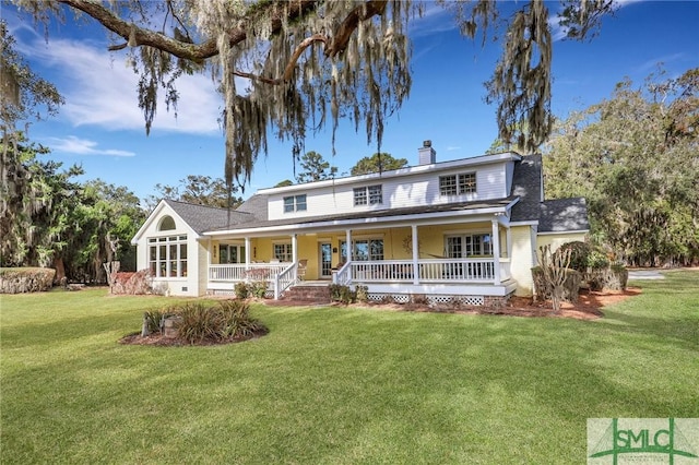 view of front of home featuring covered porch, a chimney, and a front yard