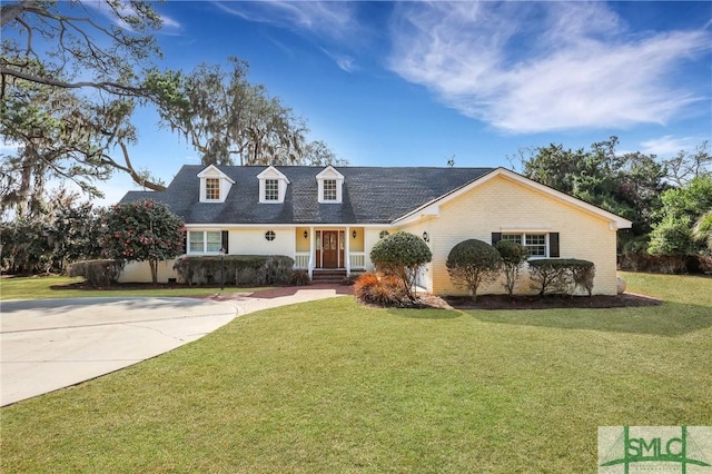 cape cod house with a front lawn and brick siding