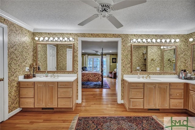 ensuite bathroom with wallpapered walls, ornamental molding, a textured ceiling, and ensuite bathroom