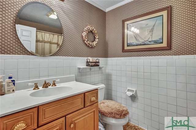 bathroom featuring wainscoting and wallpapered walls