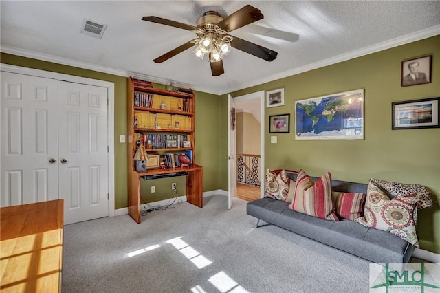 interior space featuring ceiling fan, carpet flooring, visible vents, baseboards, and crown molding