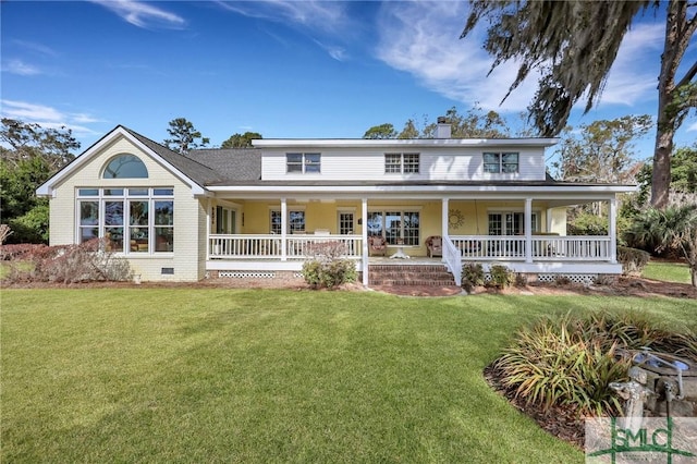 view of front of house with covered porch, a chimney, and a front yard