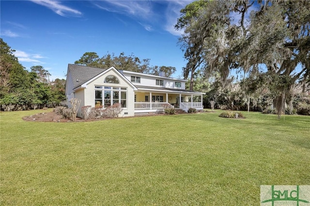 rear view of property with covered porch, a yard, a chimney, and crawl space