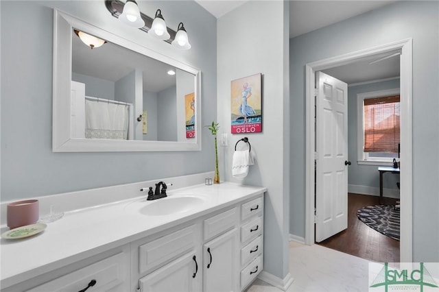 full bathroom featuring vanity and baseboards