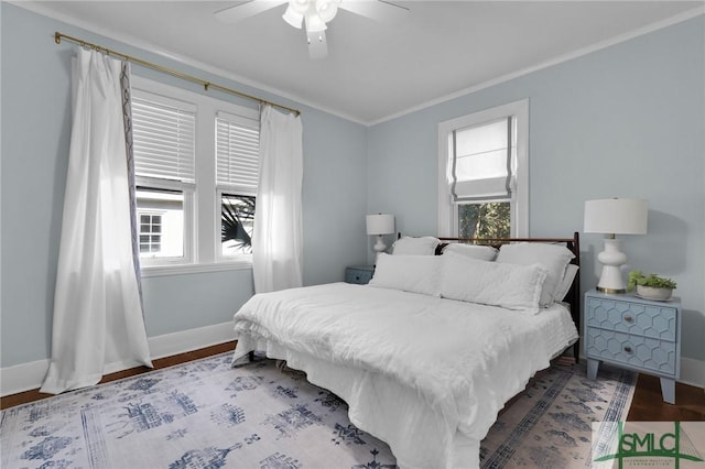 bedroom with ceiling fan, crown molding, baseboards, and wood finished floors