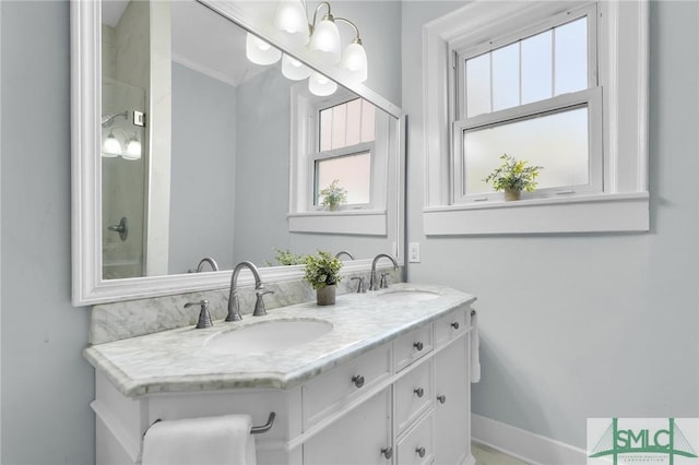 full bathroom with double vanity, baseboards, and a sink