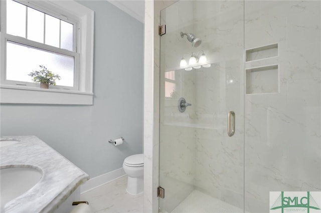 full bathroom with marble finish floor, a marble finish shower, toilet, a sink, and baseboards