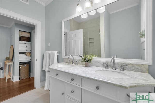 full bathroom with ornamental molding, a sink, and a shower stall