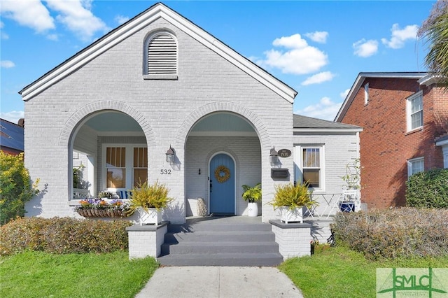 view of front of home with covered porch and brick siding