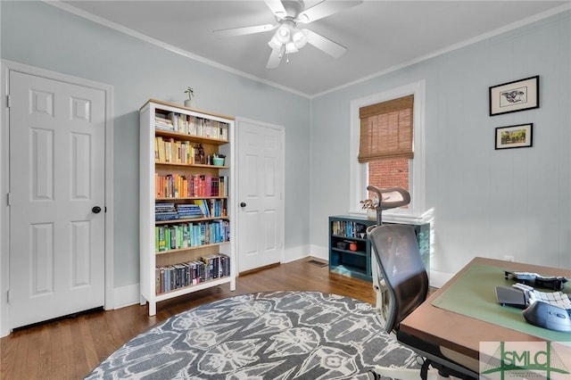 home office with ornamental molding, dark wood-type flooring, a ceiling fan, and baseboards