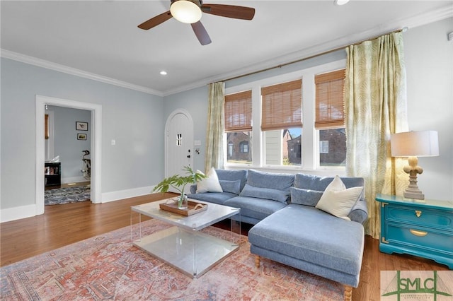 living area with recessed lighting, ornamental molding, a ceiling fan, wood finished floors, and baseboards