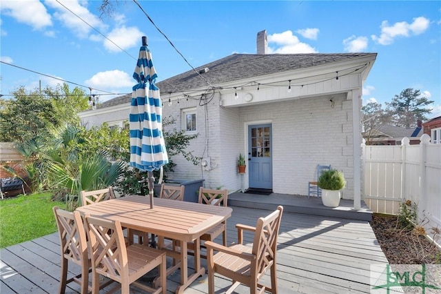 wooden deck with outdoor dining space and fence