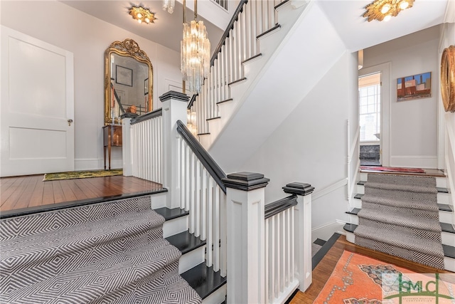 staircase featuring baseboards and wood finished floors