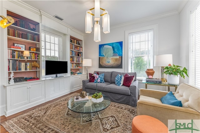 living area featuring visible vents, ornamental molding, wood finished floors, and built in shelves