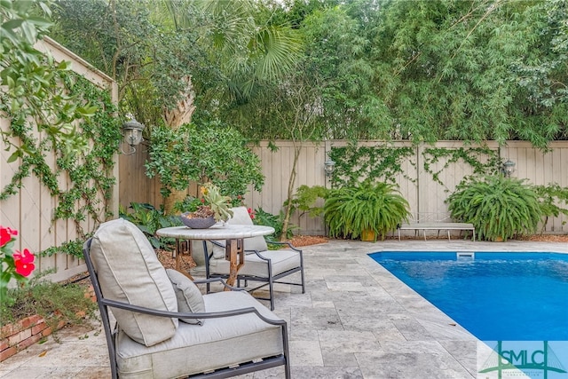 view of swimming pool featuring a fenced in pool, outdoor dining area, a fenced backyard, and a patio