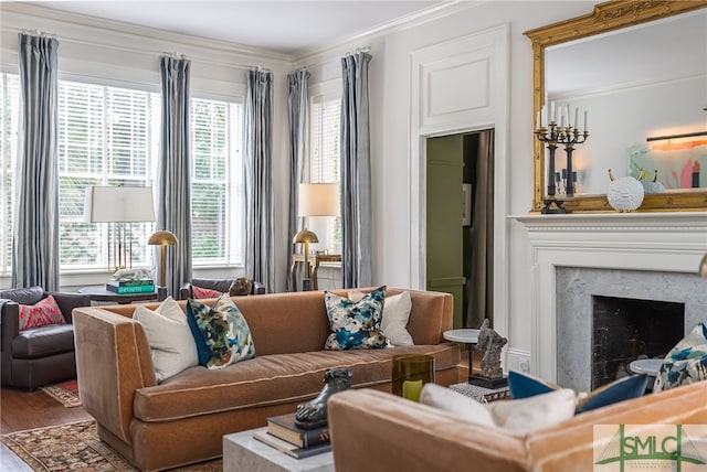 living area with ornamental molding, a fireplace, and wood finished floors