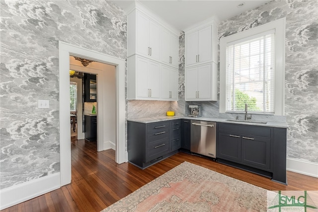 kitchen with white cabinets, dark wood-style floors, gray cabinets, stainless steel dishwasher, and a sink