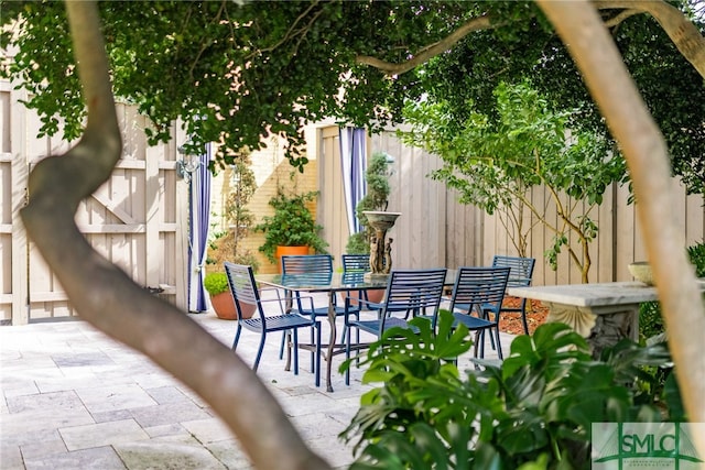 view of patio with outdoor dining space and fence