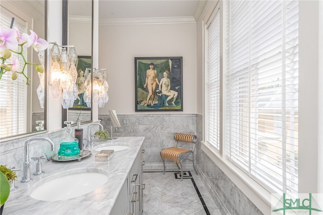 bathroom with double vanity, crown molding, a sink, and wainscoting