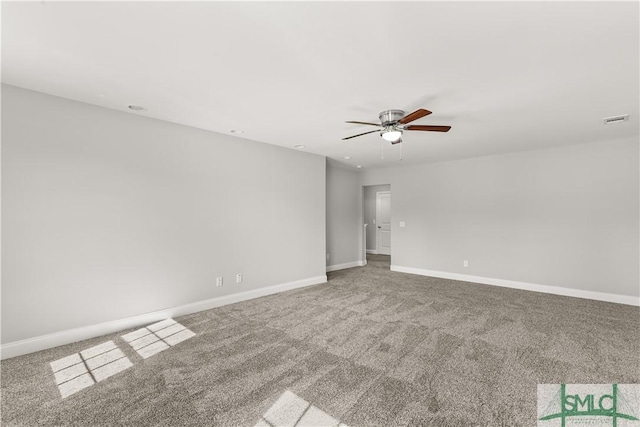 carpeted empty room featuring baseboards, visible vents, and ceiling fan