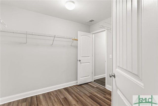 spacious closet featuring visible vents and dark wood finished floors