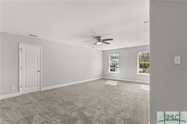 carpeted empty room with ceiling fan, visible vents, and baseboards