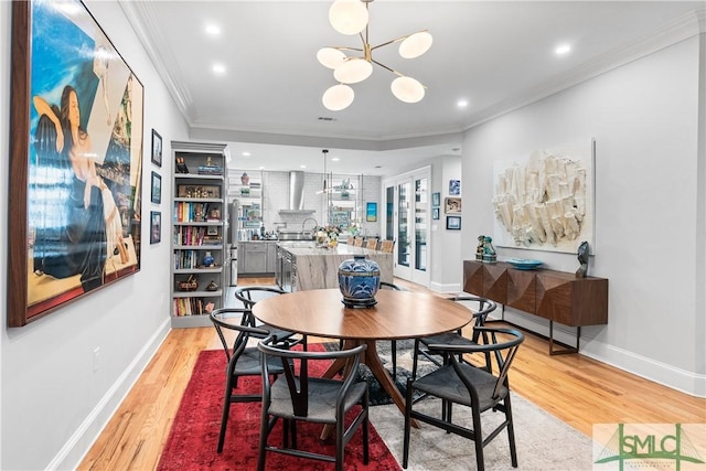 dining area featuring light wood-style floors, baseboards, ornamental molding, and recessed lighting