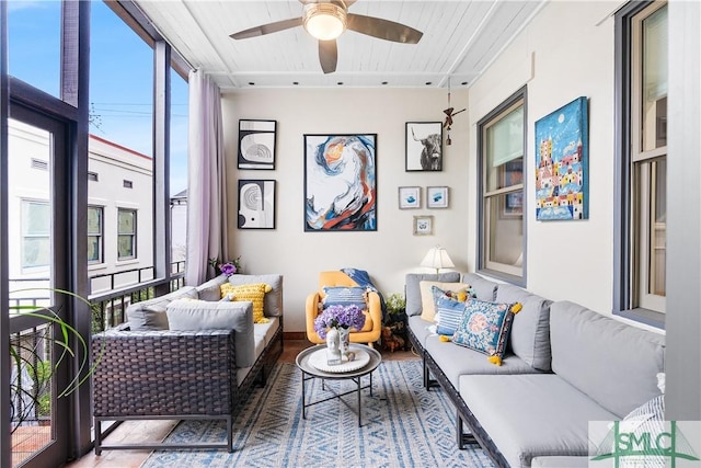 living area with a ceiling fan and expansive windows