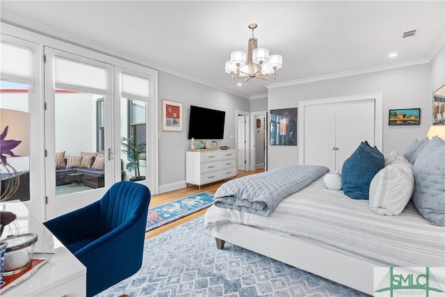 bedroom with a chandelier, ornamental molding, wood finished floors, and access to exterior