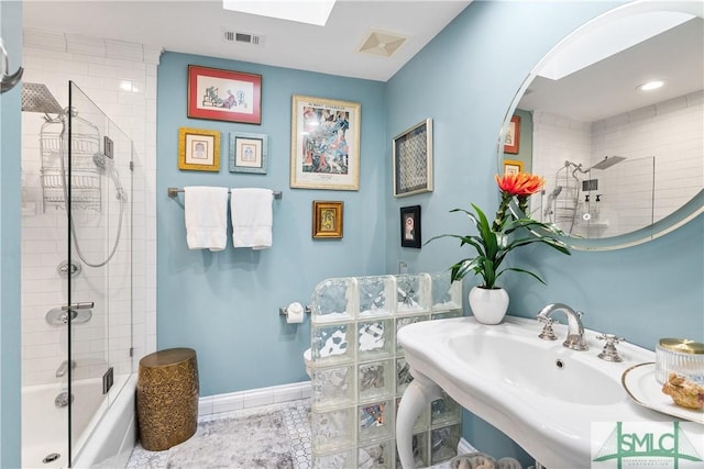 bathroom with visible vents, baseboards, tile patterned flooring, combined bath / shower with glass door, and a sink