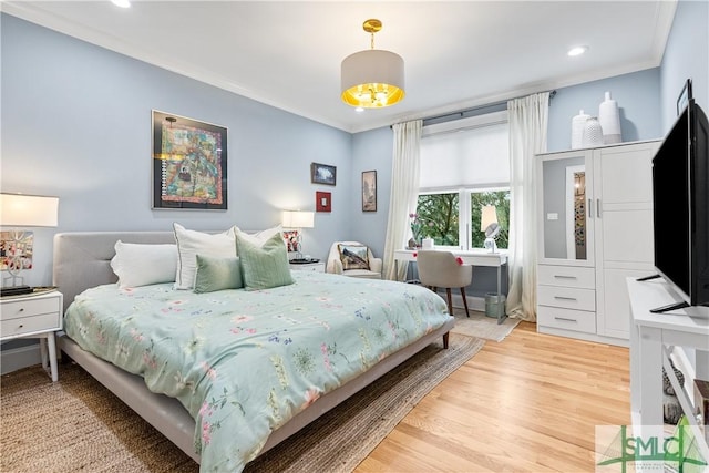 bedroom featuring light wood-type flooring and crown molding