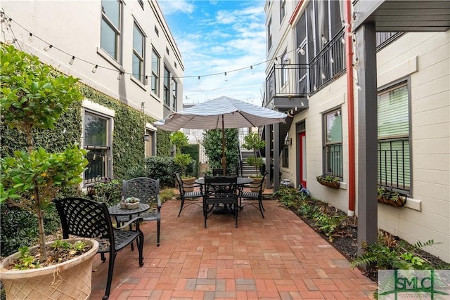 view of patio with outdoor dining space and a balcony