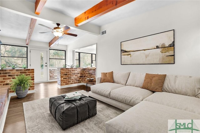 living area with a ceiling fan, visible vents, wood finished floors, and beamed ceiling