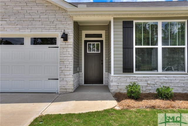 doorway to property with a garage, stone siding, and a shingled roof