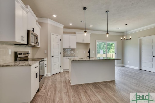 kitchen featuring ornamental molding, stainless steel appliances, light wood finished floors, and a sink