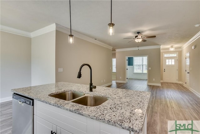 kitchen featuring crown molding, stainless steel dishwasher, open floor plan, a sink, and wood finished floors