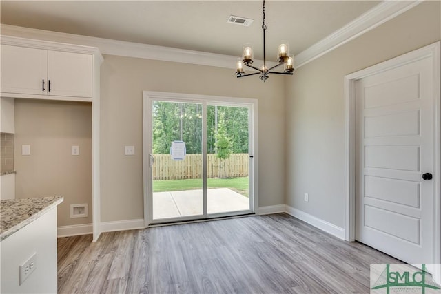 unfurnished dining area featuring light wood finished floors, baseboards, visible vents, and ornamental molding